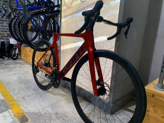 a red bike parked next to a building