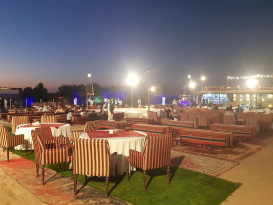 a group of tables and chairs sitting on top of a grass covered field